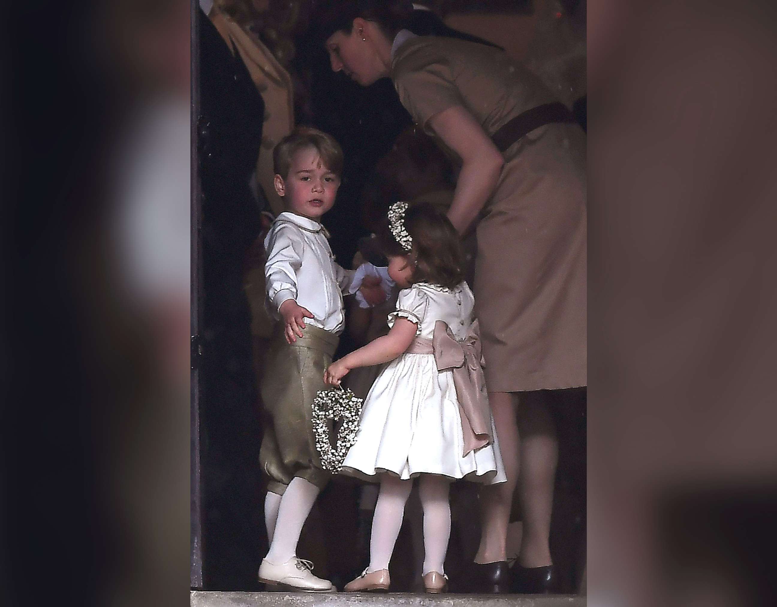 PHOTO: Britain's prince George, a pageboy, and princess Charlotte, a bridesmaid, stand with their nanny as they attend the wedding of their aunt Pippa Middleton to James Matthews at St Mark's Church in Englefield, west of London, May 20, 2017.