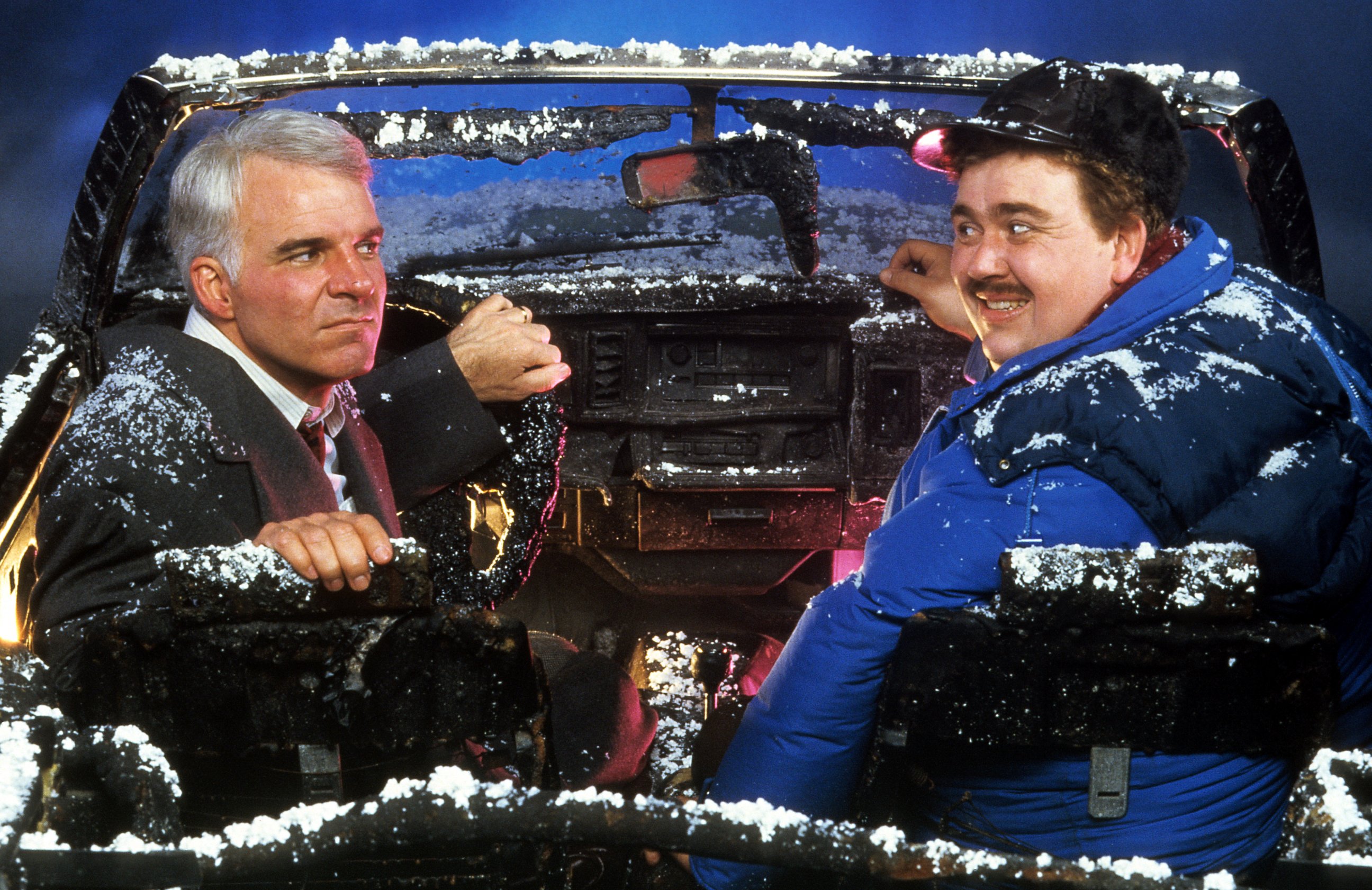 PHOTO: Steve Martin and John Candy sit in a destroyed car in a scene from the film 'Planes, Trains & Automobiles', 1987. 