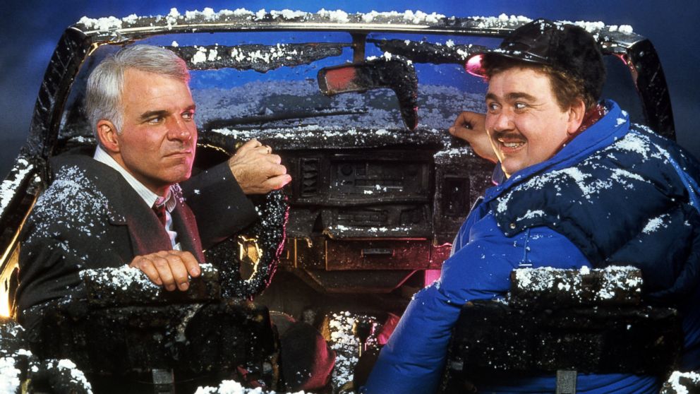 Steve Martin and John Candy sit in a destroyed car in a scene from the film 'Planes, Trains & Automobiles', 1987. 