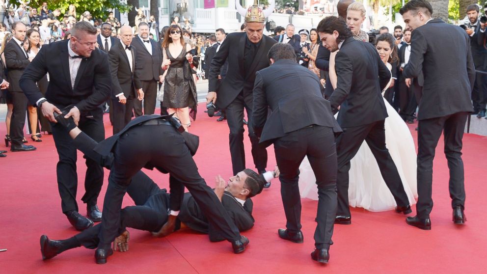 PHOTO: A man is held by security after invading the read carpet at the "How To Train Your Dragon 2" premiere during the 67th Annual Cannes Film Festival on May 16, 2014 in Cannes, France.