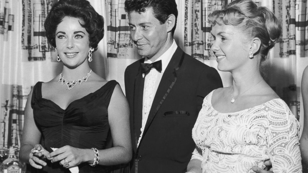 American singer Eddie Fisher stands with his wife, actress Debbie Reynolds, right, and actress Elizabeth Taylor, left, in Las Vegas, 1958. 