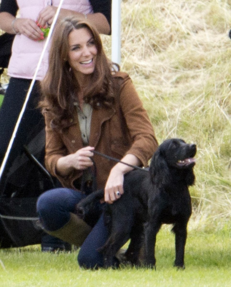 PHOTO: Catherine, Duchess Of Cambridge crouches with her dog Lupo during the Tusk Charity Polo Match at Beaufort Polo Club in Gloucestershire, England.