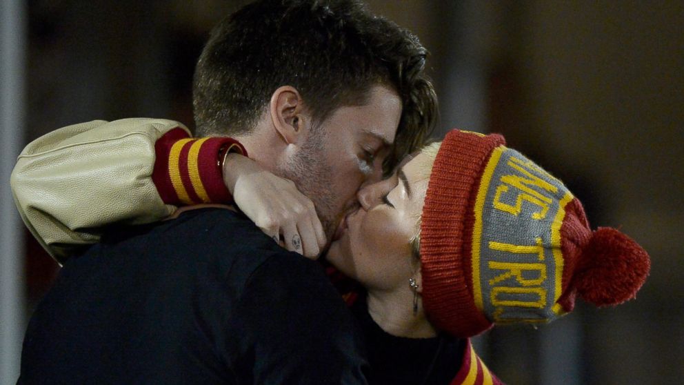 Miley Cyrus (R) kisses Patrick Schwarzenegger during the game between the California Golden Bears and the USC Trojans at Los Angeles Memorial Coliseum, Nov. 13, 2014 in Los Angeles, California. 