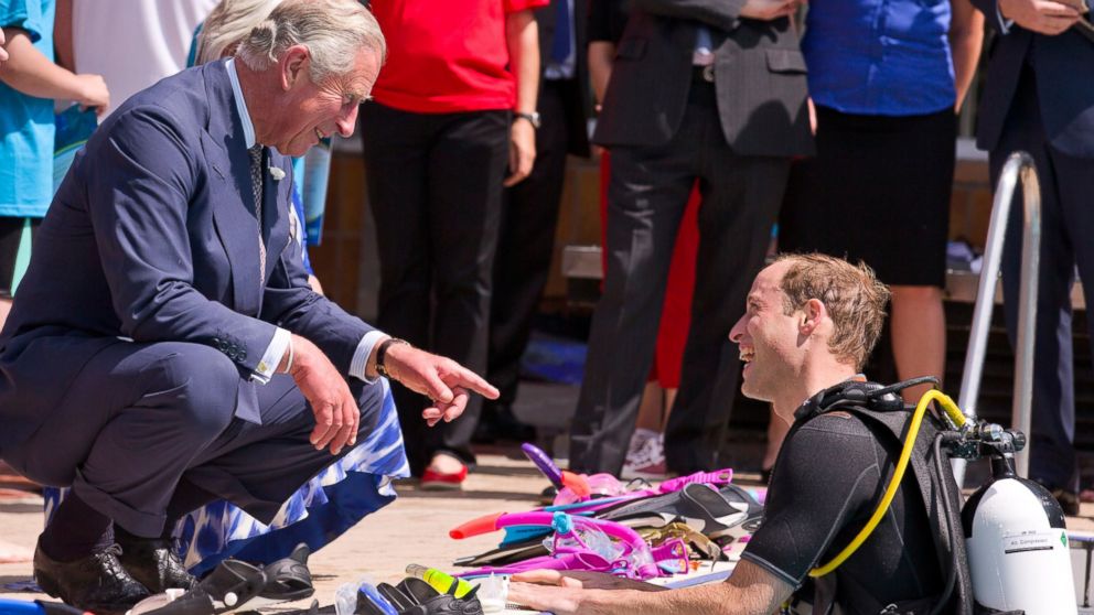 Britain's Prince Charles, Prince of Wales speaks to his son Prince William, Duke of Cambridge as he scuba dives with British Sub-Aqua Club members at a swimming pool on July 9, 2014 in London, England.