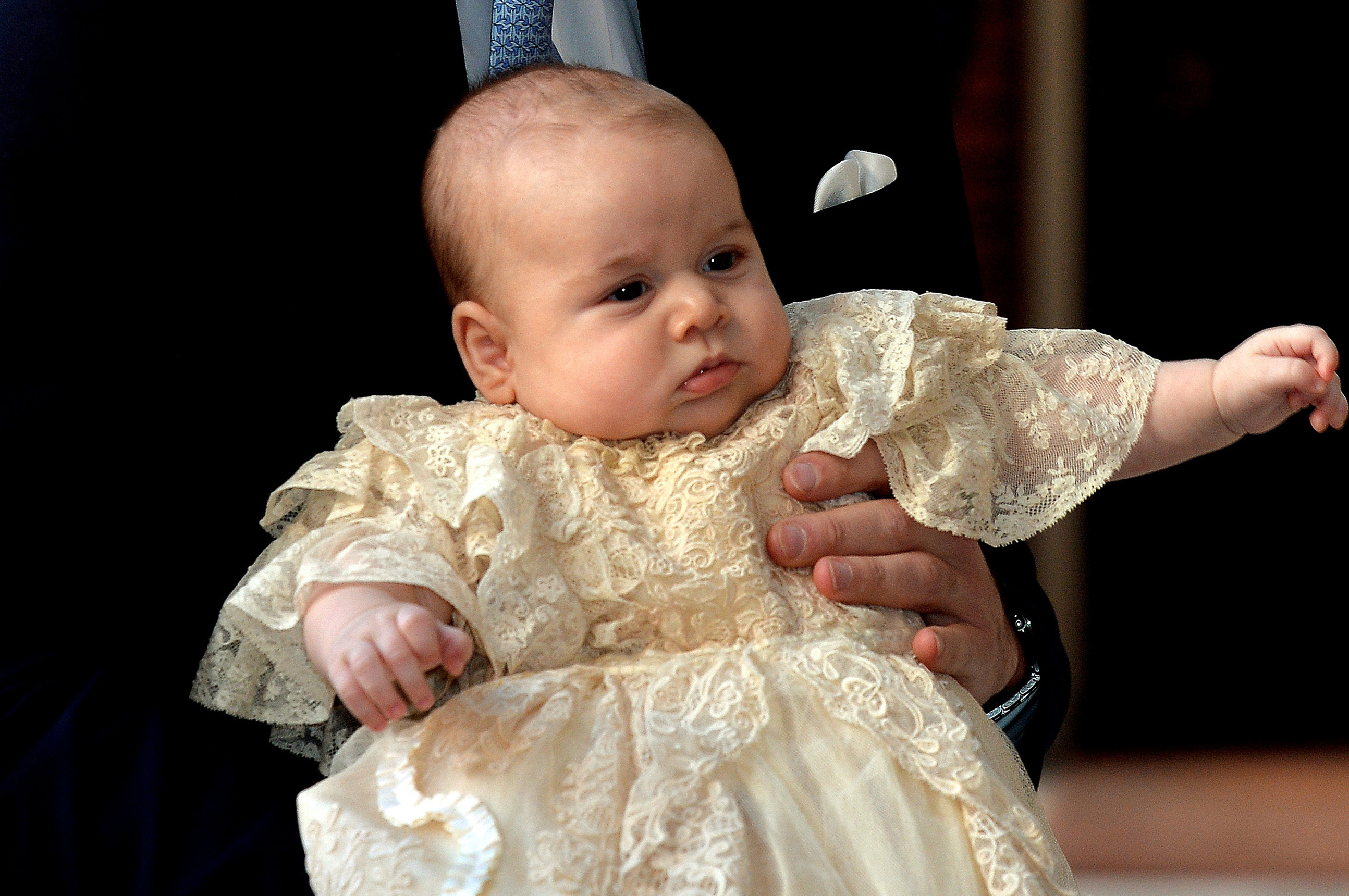 PHOTO: Britain's Prince William, Duke of Cambridge holds his son, Prince George of Cambridge, as he arrives at Chapel Royal in St James's Palace in central London for the christening of the three month-old baby on October 23, 2013. 