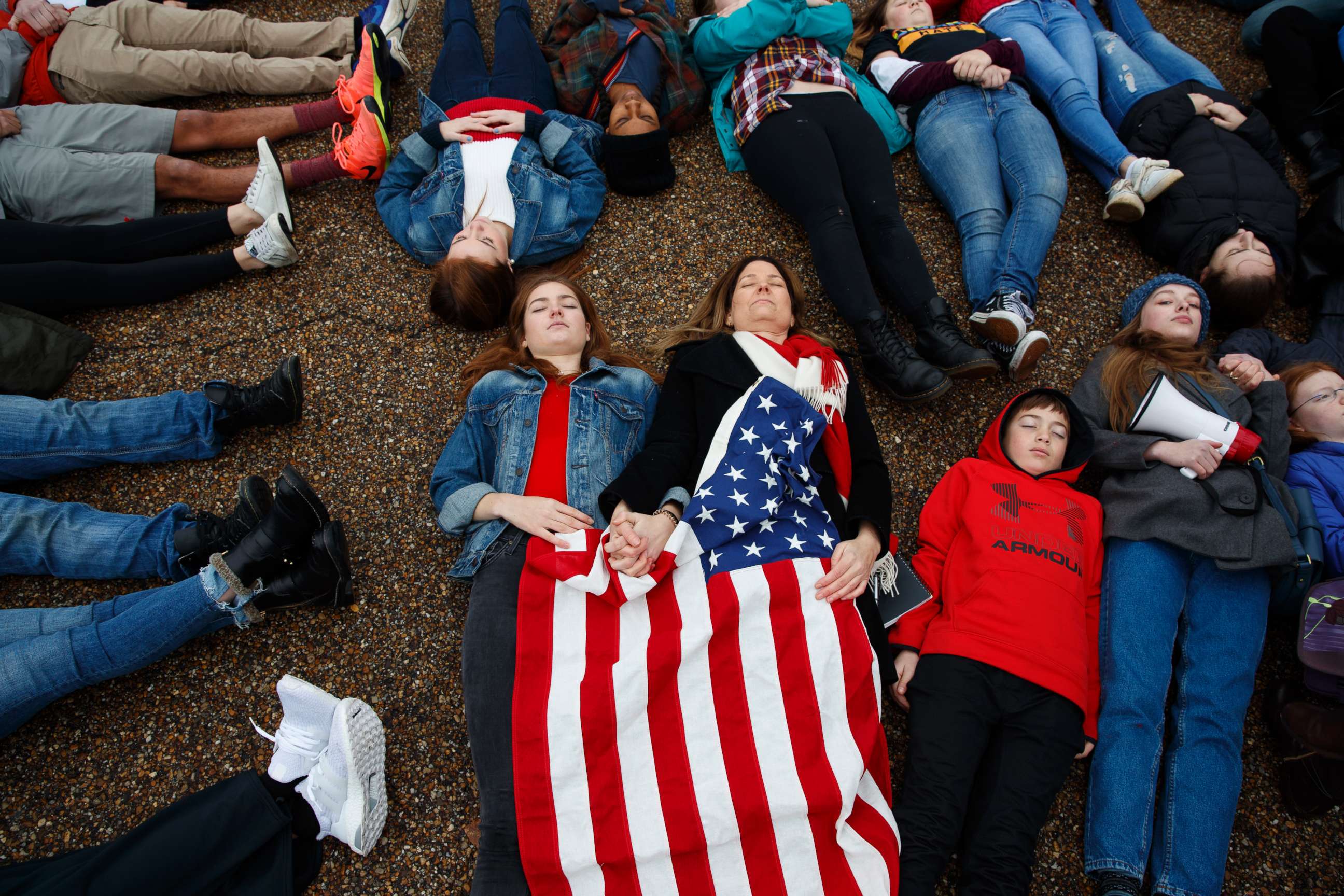 PHOTO: Abby Spangler and her daughter Eleanor Spangler Neuchterlein, 16, hold hands as they participate in a "lie-in" during a protest in favor of gun control reform in front of the White House, Feb. 19, 2018, in Washington.