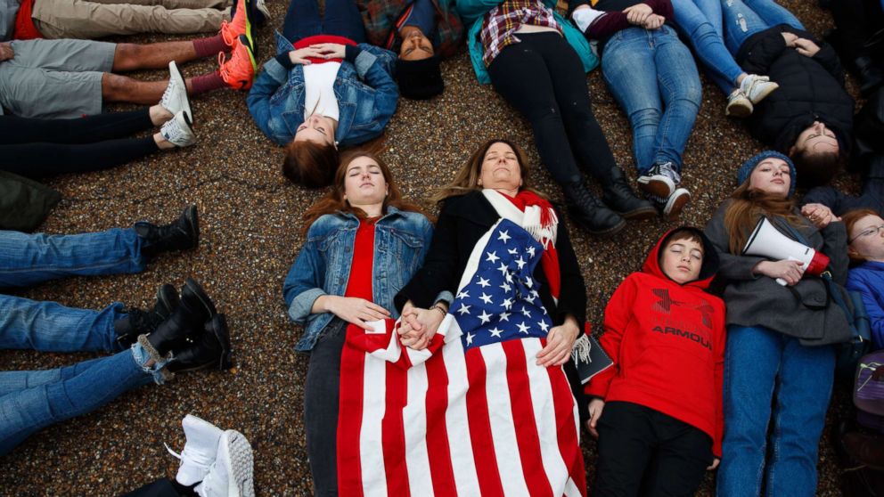 PHOTO: Abby Spangler and her daughter Eleanor Spangler Neuchterlein, 16, hold hands as they participate in a "lie-in" during a protest in favor of gun control reform in front of the White House, Feb. 19, 2018, in Washington.