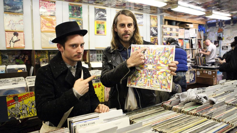 PHOTO: Elijah Wood, left, and Zach Cowie, right, present a copy of Secret Circuit's album 'Tactile Galactics' at A1 Records in New York City on Jan. 19, 2015. 
