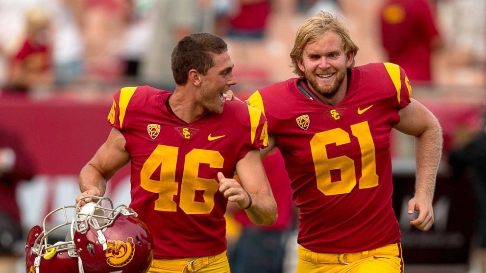 PHOTO: USC long snapper, Jake Olson, right, who has been blind since the age of 12, runs off the field with teammate Wyatt Schmidt after he snapped an extra point.