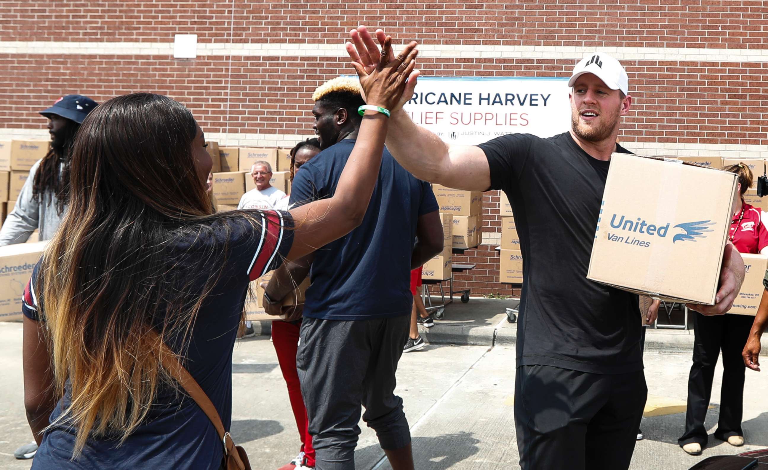 PHOTO: Anna Ucheomumu high fives Houston Texans defensive end J.J. Watt after loading a car with relief supplies for people impacted by Hurricane Harvey on Sept. 3, 2017, in Houston.