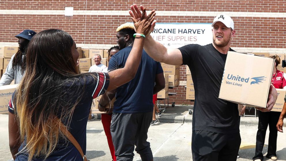 PHOTO: Anna Ucheomumu high fives Houston Texans defensive end J.J. Watt after loading a car with relief supplies for people impacted by Hurricane Harvey on Sept. 3, 2017, in Houston.