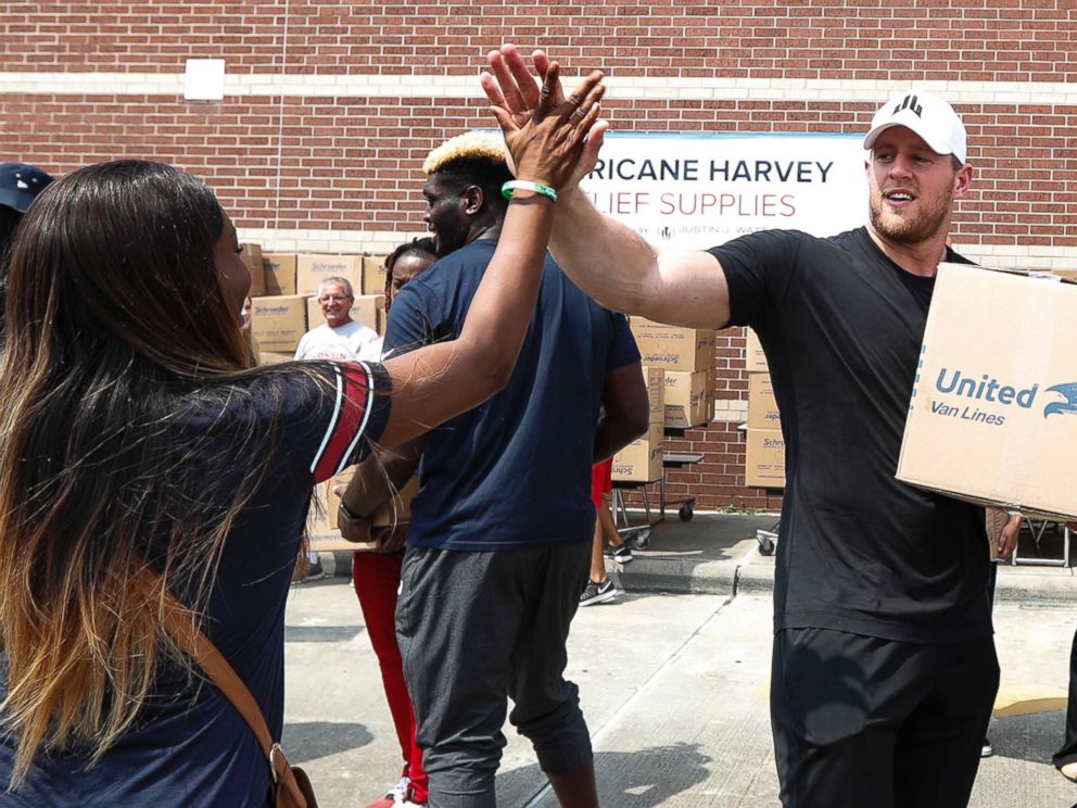 PHOTO: Anna Ucheomumu high fives Houston Texans defensive end J.J. Watt after loading a car with relief supplies for people impacted by Hurricane Harvey on Sept. 3, 2017, in Houston.