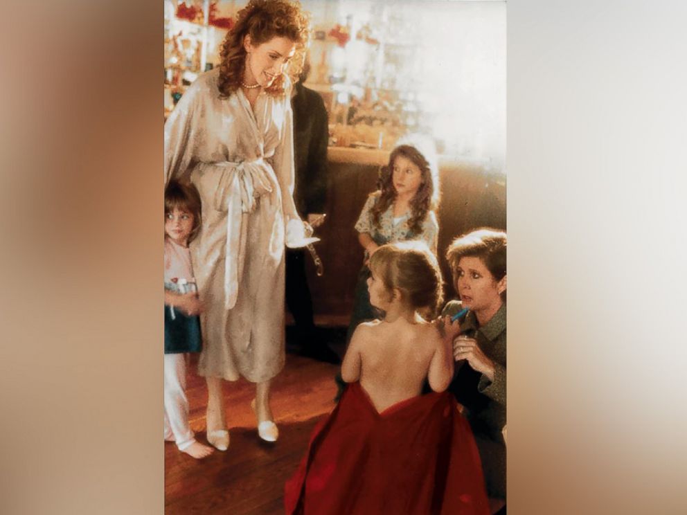 PHOTO: Joely Fisher watches as Carrie Fisher, kneeling, helps dress her daughter, Billie Lourd.