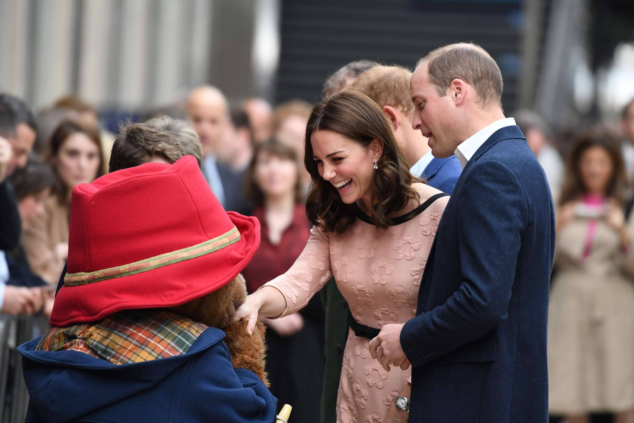 Britain's Catherine, Duchess of Cambridge shakes hands with a person in a Paddington Bear outfit along with her husband Britain's Prince William, Duke of Cambridge, as they attend a charities event at Paddington train station in London, Oct. 16, 2017.