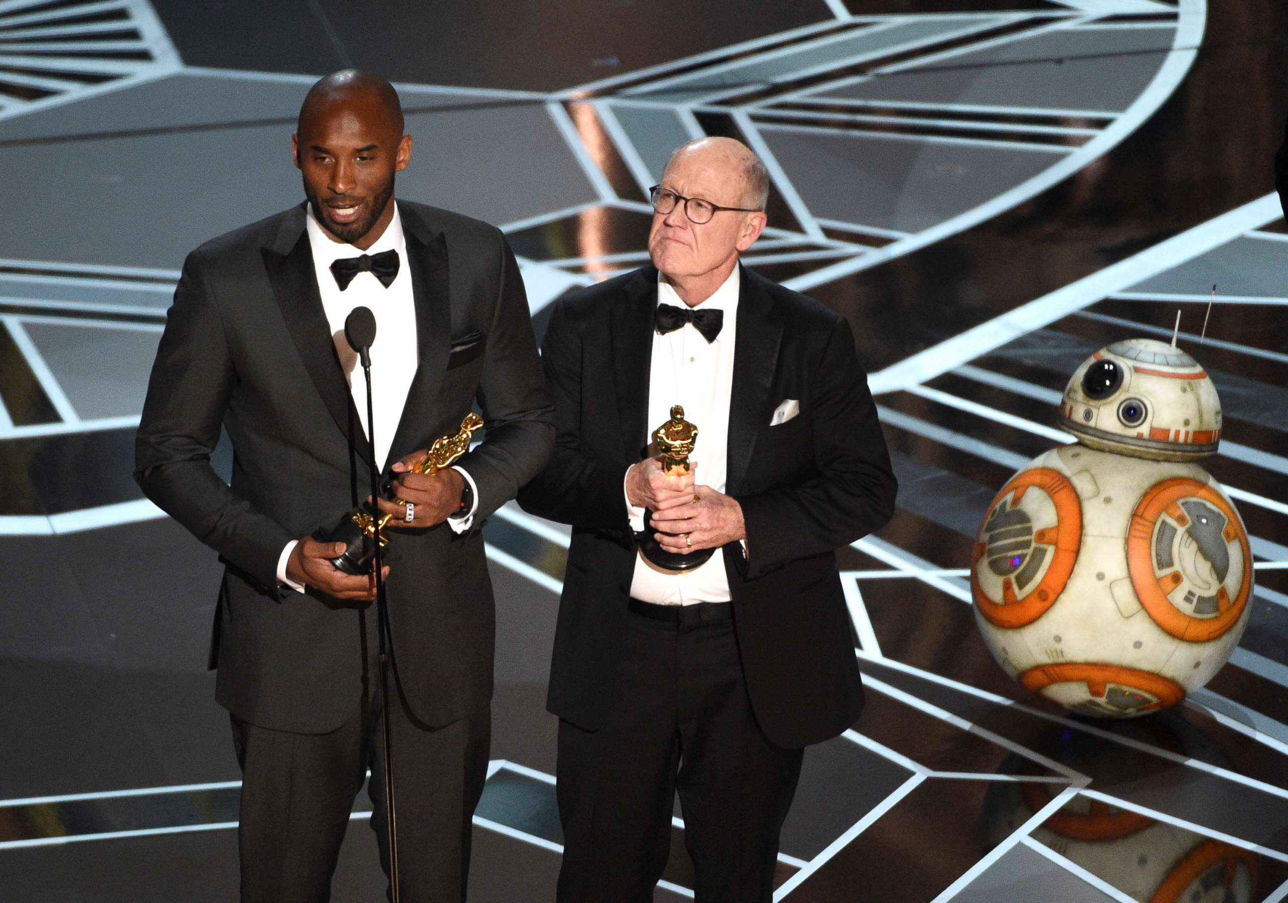 PHOTO: Kobe Bryant and Glen Keane accept the award for best animated short for "Dear Basketball" at the Oscars, March 4, 2018, at the Dolby Theatre in Los Angeles. BB-8 appears at right.
