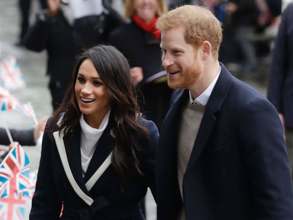PHOTO: Meghan Markle and Britains Prince Harry are greeted by flag waving school children as they arrive to take part in an event for young women as part of International Womens Day in Birmingham,England, March 8, 2018.