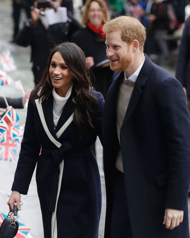 PHOTO: Meghan Markle and Britain's Prince Harry are greeted by flag waving school children as they arrive to take part in an event for young women as part of International Women's Day in Birmingham,England, March 8, 2018.