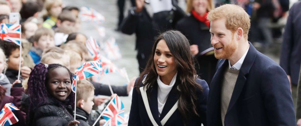 PHOTO: Meghan Markle and Britains Prince Harry are greeted by flag waving school children as they arrive to take part in an event for young women as part of International Womens Day in Birmingham, central England, March 8, 2018.