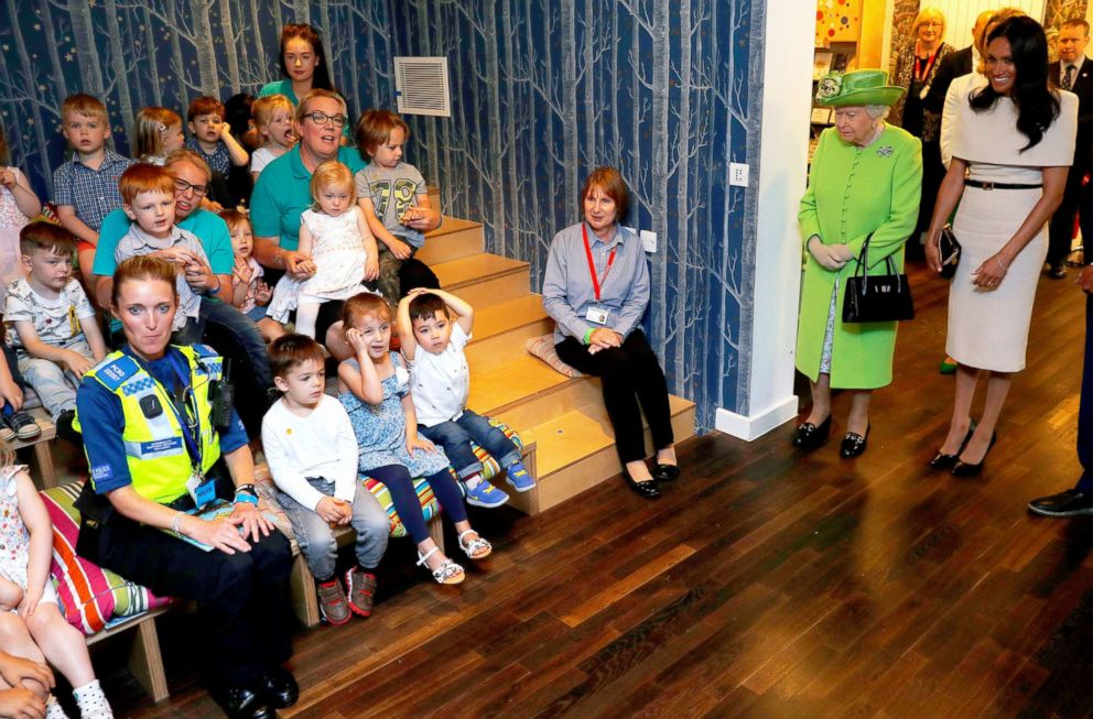 PHOTO: Children sit as Queen Elizabeth II and Meghan, Duchess of Sussex arrive for their visit to the Storyhouse, June 14, 2018, in Chester, England.