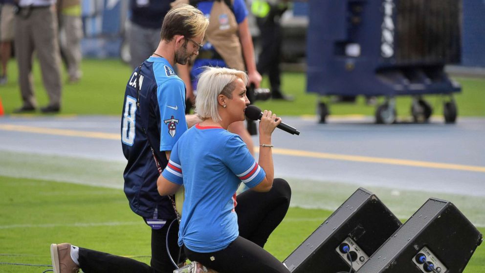 Recording artist Meghan Linsey kneels after singing the national anthem before the game between the Tennessee Titans and the Seattle Seahawks at Nissan Stadium, Sept. 24, 2017.