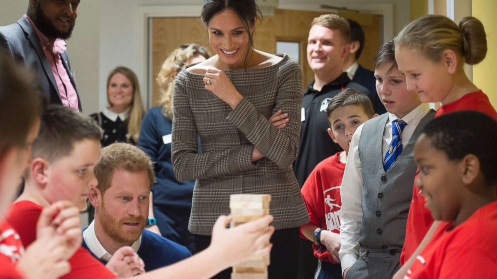 PHOTO: Britain's Prince Harry and Meghan Markle reacts as they watch a game of Jenga, during a visit to Star Hub, a community and leisure center in Cardiff, Wales, Jan. 18, 2018. 