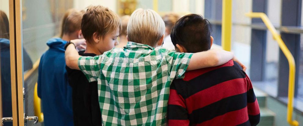 PHOTO: Middle-school aged boys stand in a hallway in an undated stock photo.