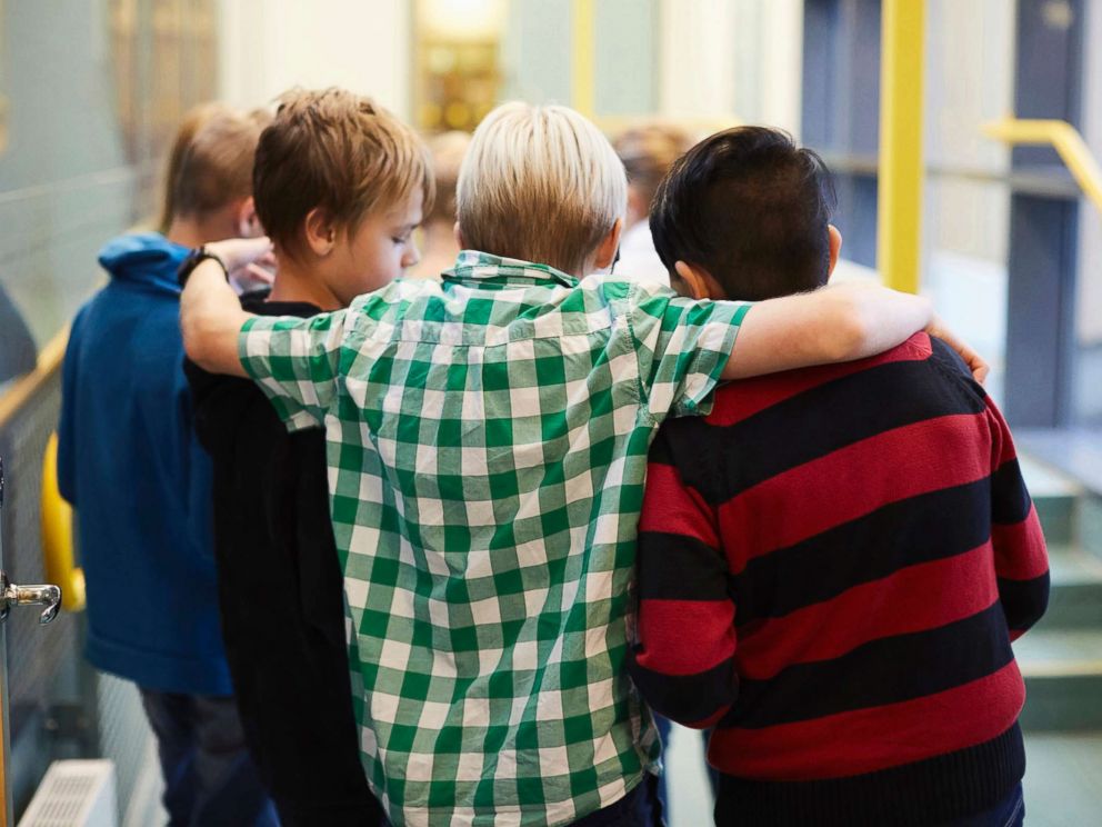 PHOTO: Middle-school aged boys stand in a hallway in an undated stock photo.