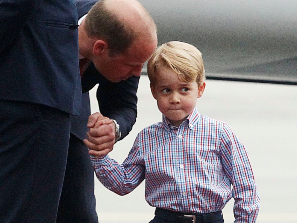 PHOTO: Britain's Prince William, left, holds the hand of his son Prince George on arrival at the airport, in Warsaw, Poland, July 17, 2017.