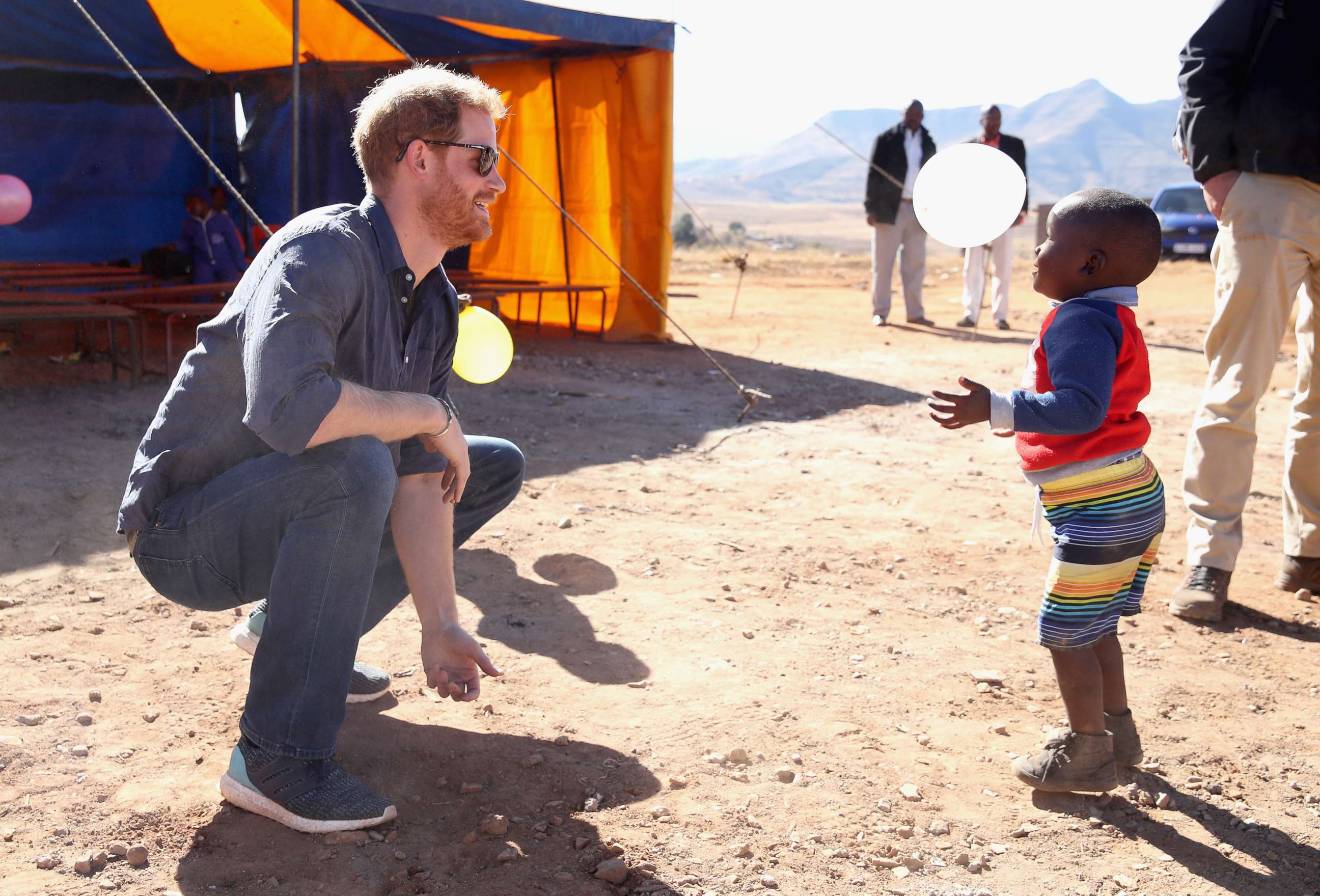 PHOTO: Prince Harry, Duke of Sussex plays with children holding balloons during the official opening of The Dining Hall at Phelisanong Childrens Home on June 23, 2018 in Leribe, Lesotho.