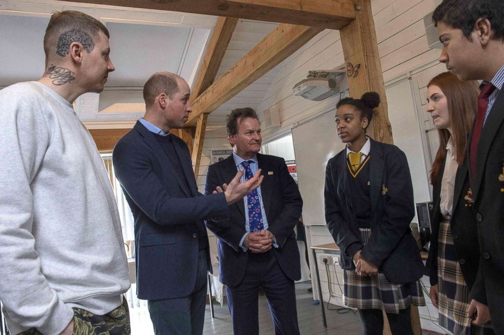 PHOTO: Britain's Prince William, accompanied by rapper Stephen Manderson interacts with students taking part in an assembly on cyber-bullying and its effect on young people's mental health during their visit to Burlington Academy, London on Feb. 8, 2018.