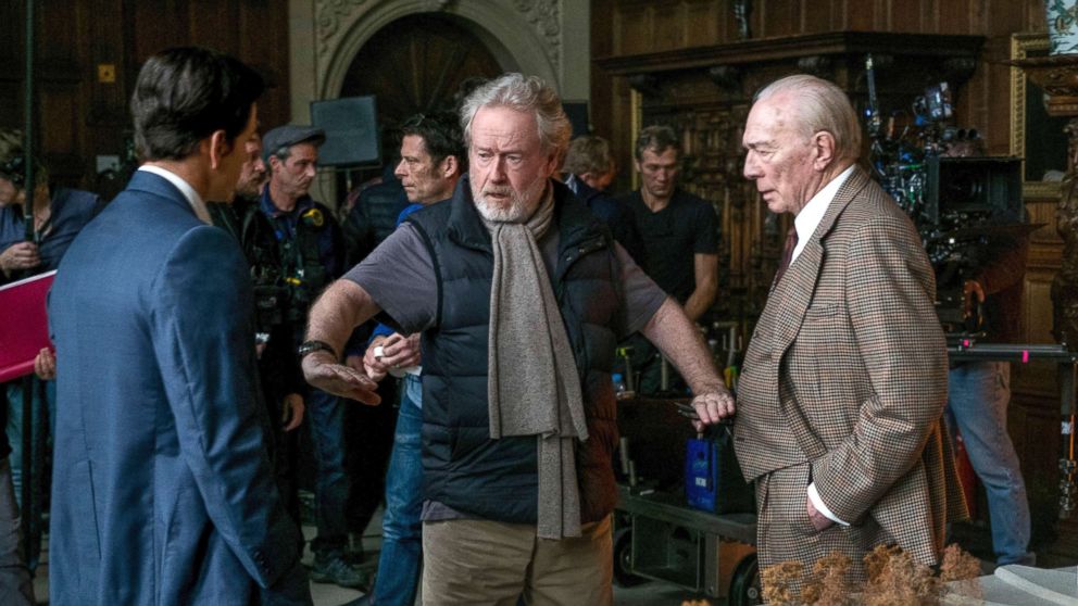 Mark Wahlberg, left, and Christopher Plummer, right, listening to director Ridley Scott on the set of "All The Money In The World." 