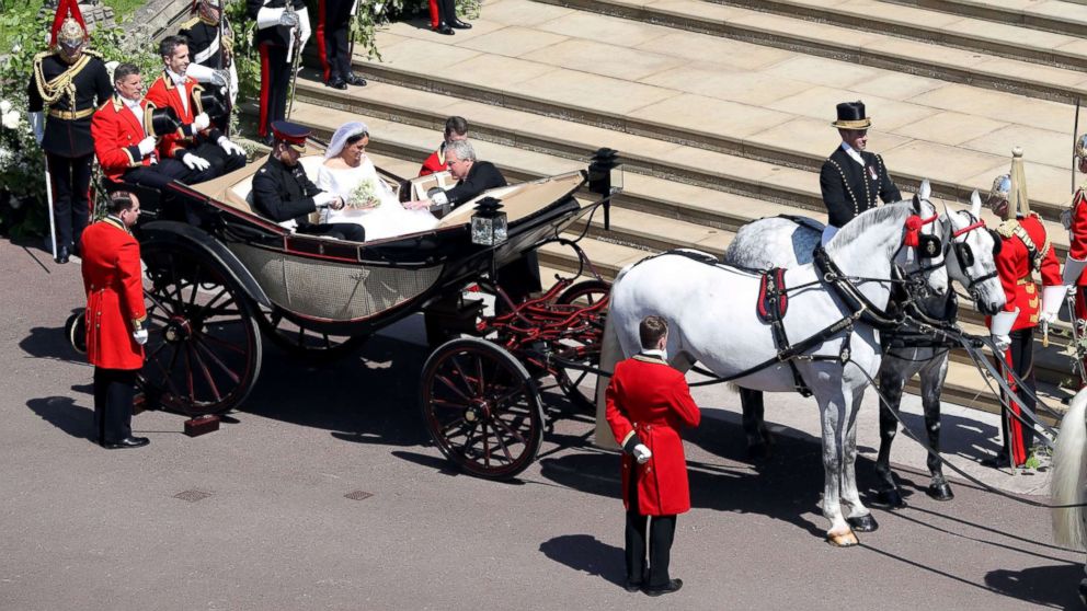 PHOTO: Prince Harry, Duke of Sussex and his wife Meghan, Duchess of Sussex get into the carriage after their wedding ceremony at St George's Chapel, Windsor Castle, in Windsor, May 19, 2018 to start their wedding procession. 