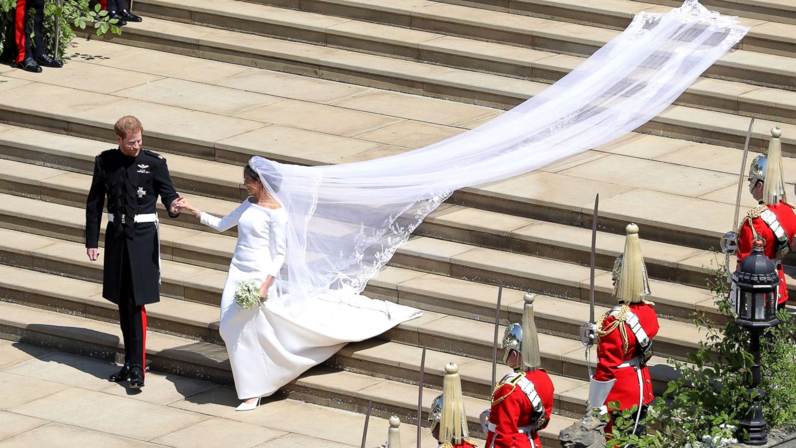 PHOTO: Prince Harry, Duke of Sussex and his wife Meghan, Duchess of Sussex walk down the west steps of St George's Chapel, Windsor Castle, in Windsor, on May 19, 2018 after their wedding ceremony.