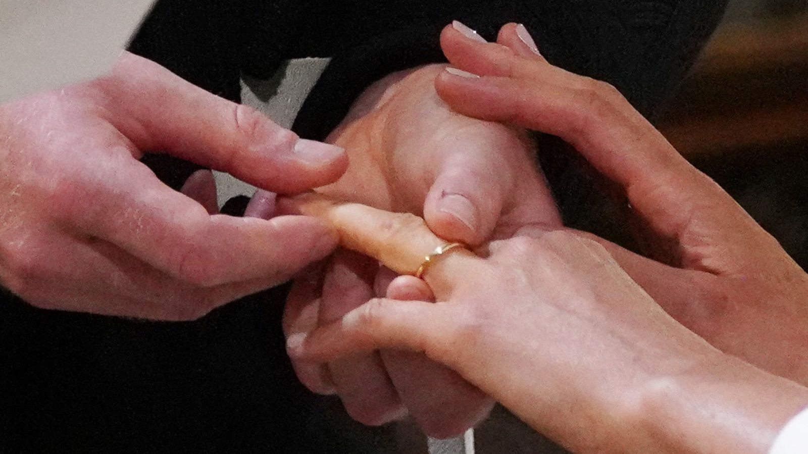 PHOTO: Prince Harry, Duke of Sussex, places the wedding ring on the finger of Meghan Markle during their wedding ceremony in St George's Chapel, Windsor Castle, in Windsor, on May 19, 2018.