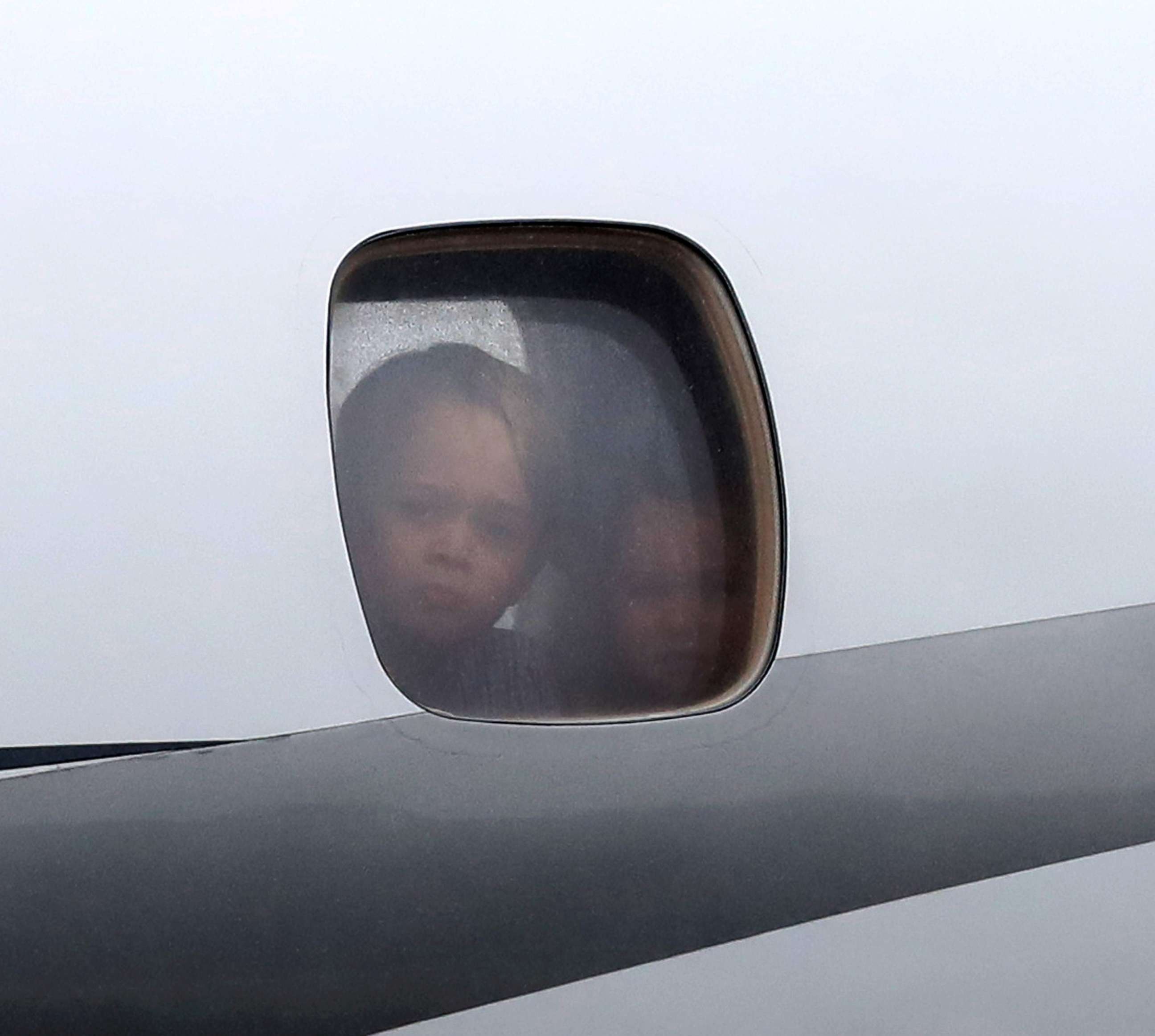 PHOTO: Prince George and Princess Charlotte peer out of a window as they arrive with Prince William and Catherine, Duchess of Cambridge on day 1 of their official visit to Poland, July 17, 2017, in Warsaw, Poland. 