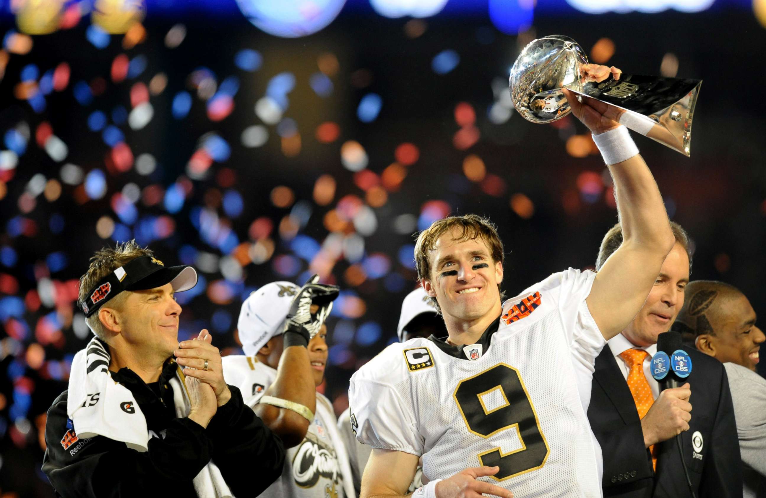 PHOTO: Drew Brees of the New Orleans Saints holds up the Vince Lombardi Trophy on the podium as head coach Sean Payton looks on after defeating the Indianapolis Colts in Super Bowl XLIV, Feb. 7, 2010, at Sun Life Stadium in Miami Gardens, Florida.