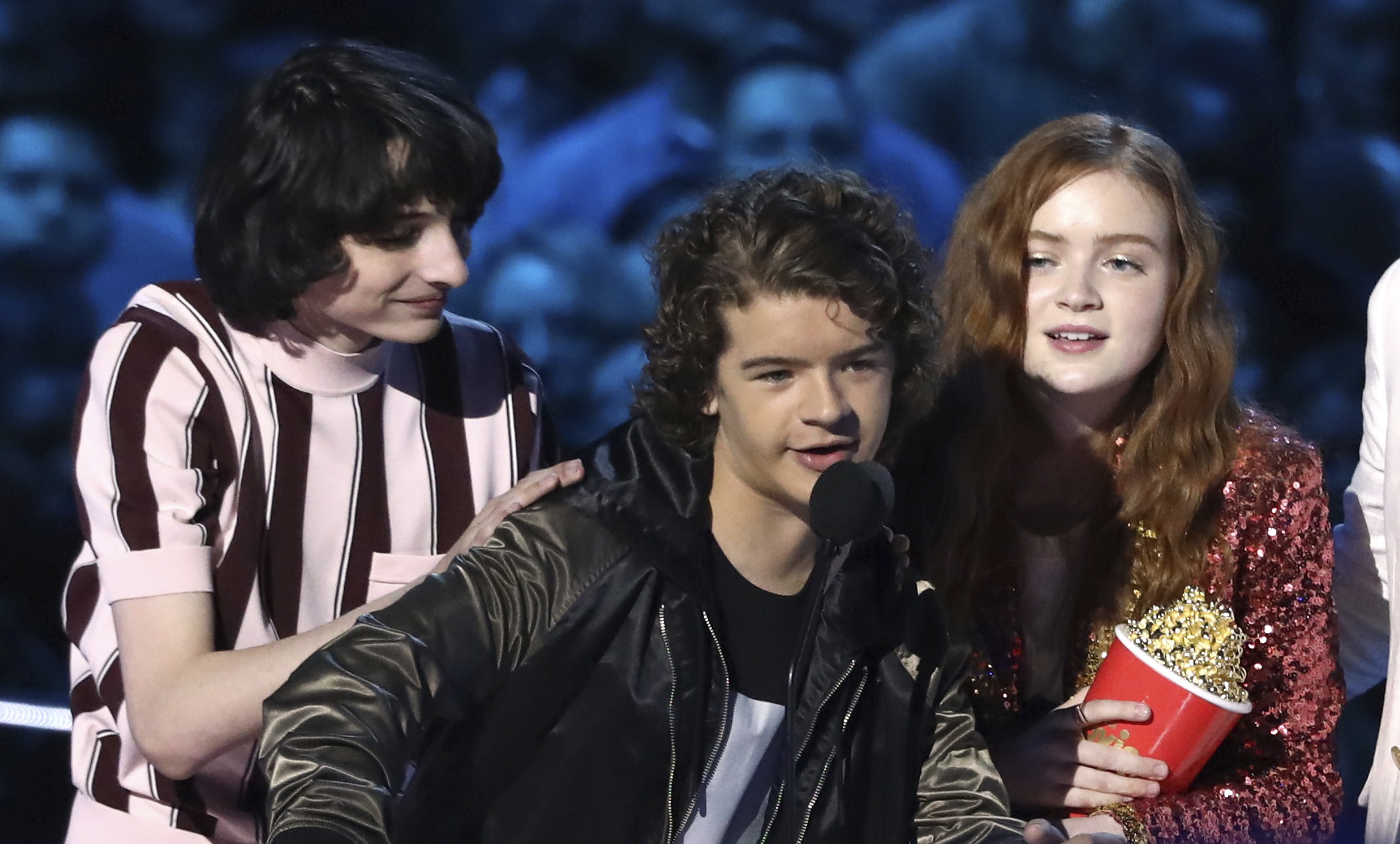 In this Saturday, June 16, 2018, photo, Finn Wolfhard, from left, Gaten Matarazzo and Sadie Sink accept the award for best show for "Stranger Things" at the MTV Movie and TV Awards at the Barker Hangar in Santa Monica, Calif.