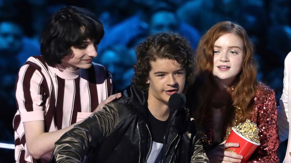 In this Saturday, June 16, 2018, photo, Finn Wolfhard, from left, Gaten Matarazzo and Sadie Sink accept the award for best show for "Stranger Things" at the MTV Movie and TV Awards at the Barker Hangar in Santa Monica, Calif.