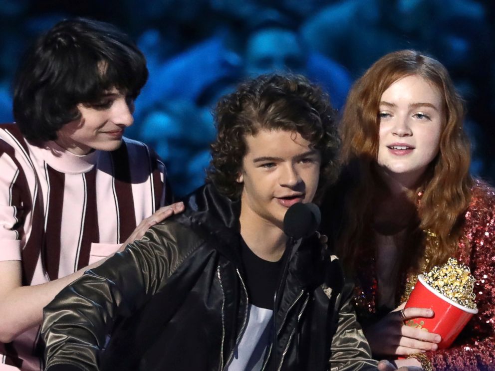 In this Saturday, June 16, 2018, photo, Finn Wolfhard, from left, Gaten Matarazzo and Sadie Sink accept the award for best show for Stranger Things at the MTV Movie and TV Awards at the Barker Hangar in Santa Monica, Calif.