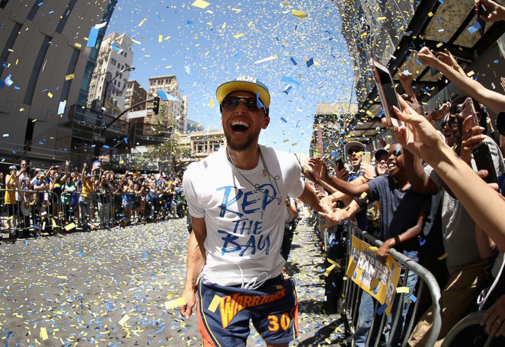 PHOTO: Stephen Curry of the Golden State Warriors celebrates with the crowd during the Golden State Warriors Victory Parade, June 12, 2018, in Oakland, Calif. 