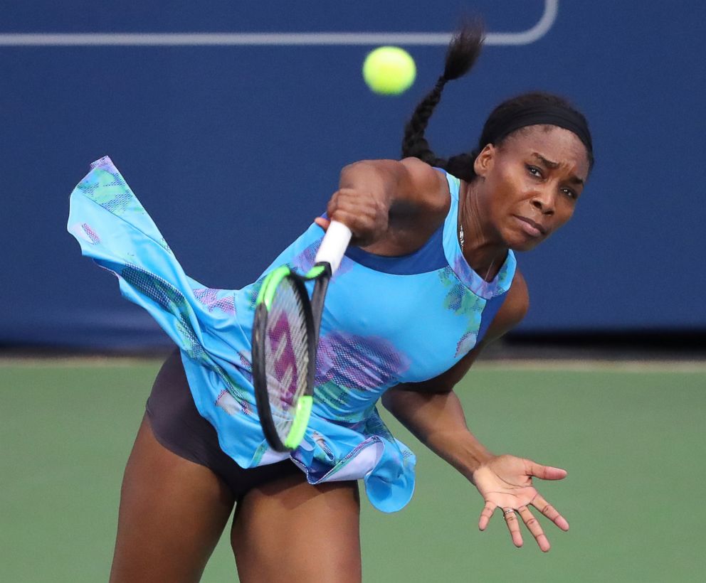 PHOTO: Venus Williams serves to Canada's Genie Bouchard in a special women's exhibition tennis match at the BB&T Atlanta Open Tournament, July 23, 2017, in Atlanta. 