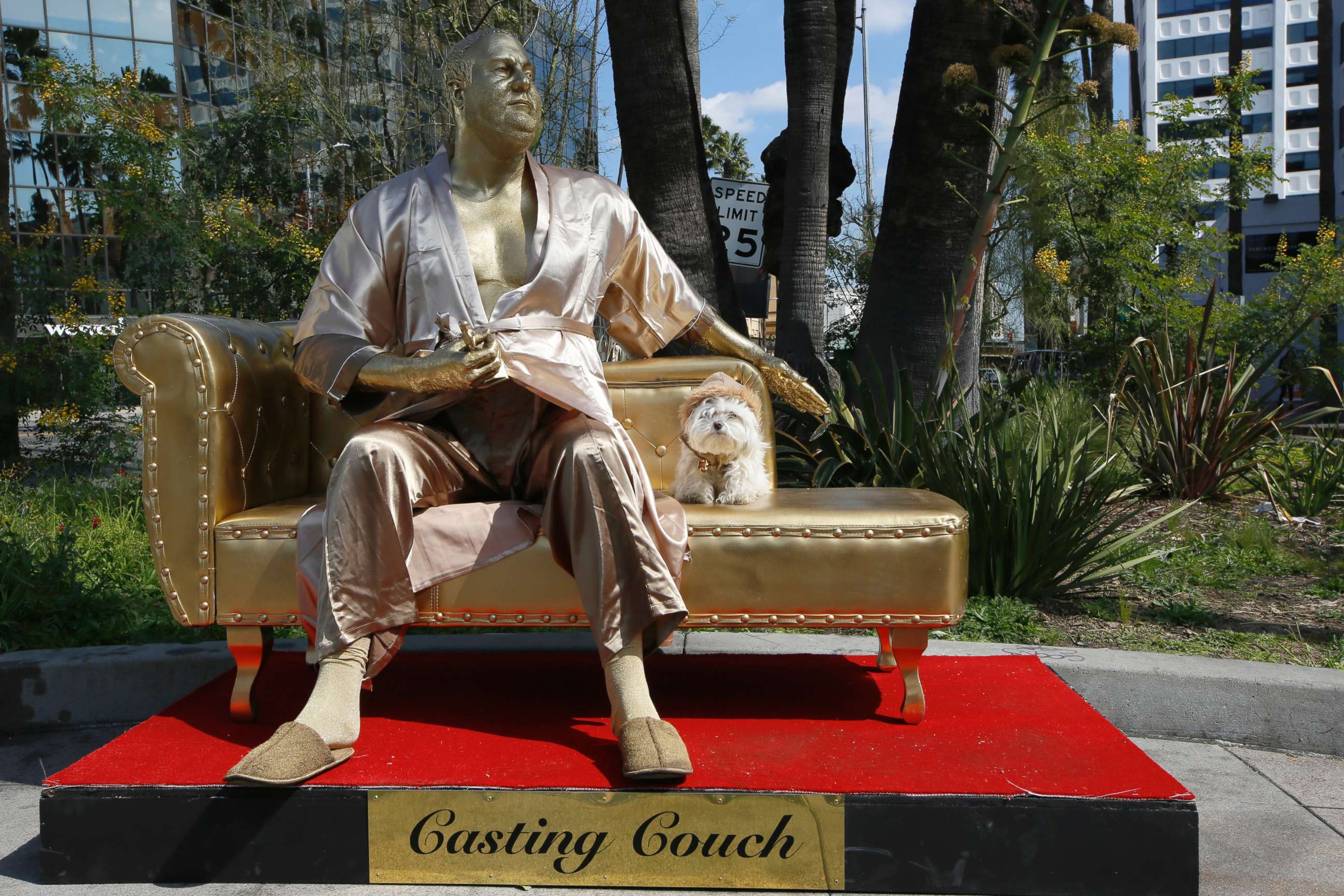 PHOTO: A dog poses next to a golden statue of a bathrobe-clad Harvey Weinstein, seated atop a couch on the sidewalk along Hollywood Blvd., in Los Angeles, March 1, 2018.