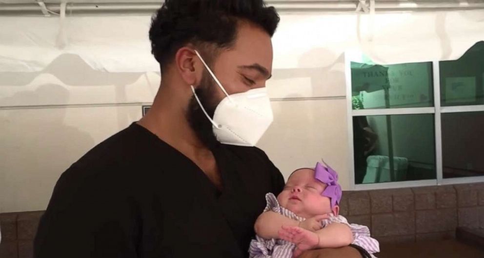 PHOTO: Dr. John Mathew, director of emergency medicine and associate chief medical officer for progressive emergency physicians at St. Joseph's Hospital in Bethpage, New York, holds Mikayla Petti on Aug. 5, 2020.