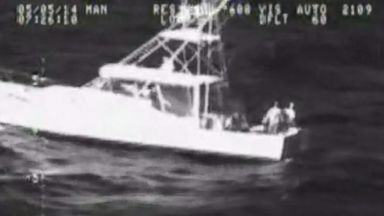 VIDEO: The two men clung to their boat after it was capsized by a rogue wave.