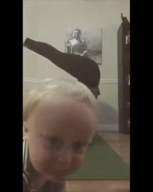 VIDEO: Toddler brilliantly photo bombs his mom's yoga headstand 