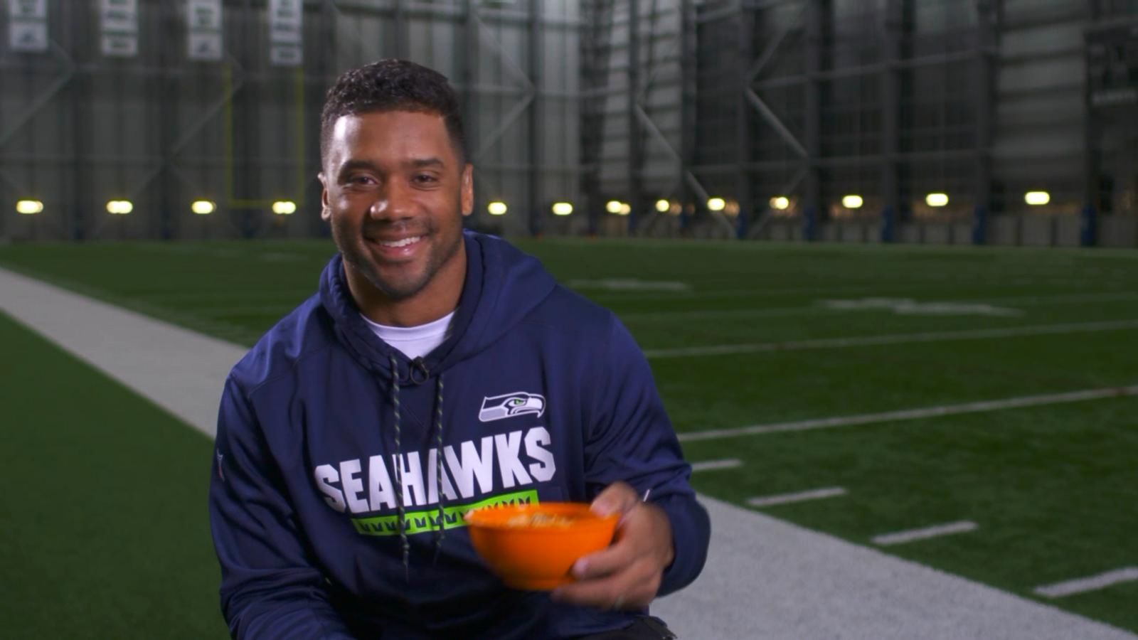 A Seattle Seahawks fan wearing a Russell Wilson jersey waves a