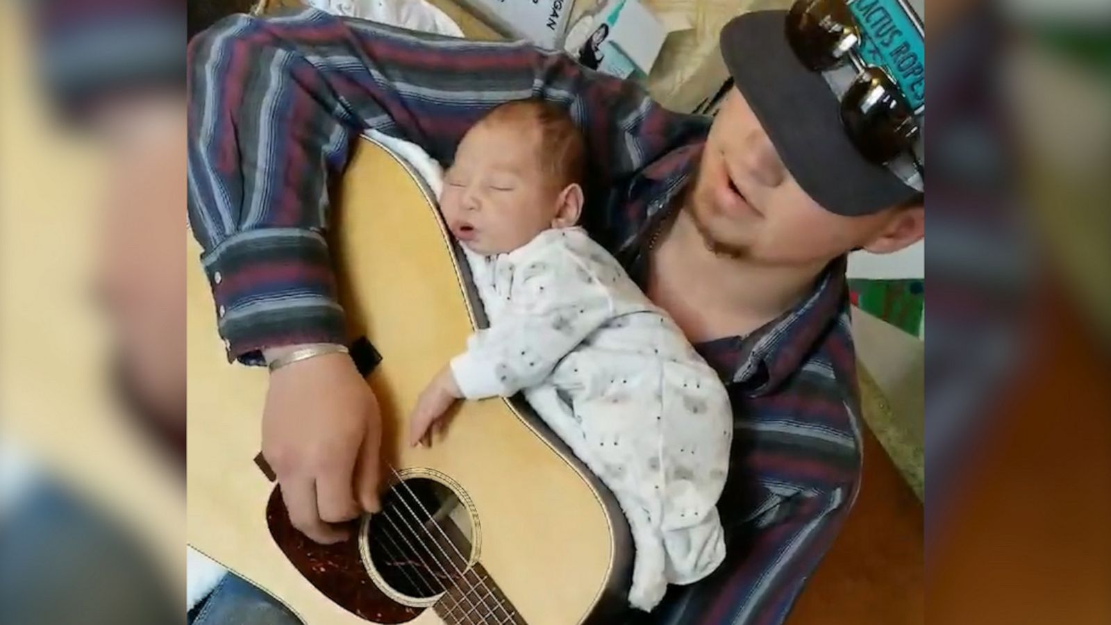 VIDEO: Dad nestles his newborn daughter on top of his guitar to lull her to sleep