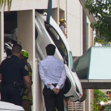 VIDEO: Firefighters rescue woman from dangling car