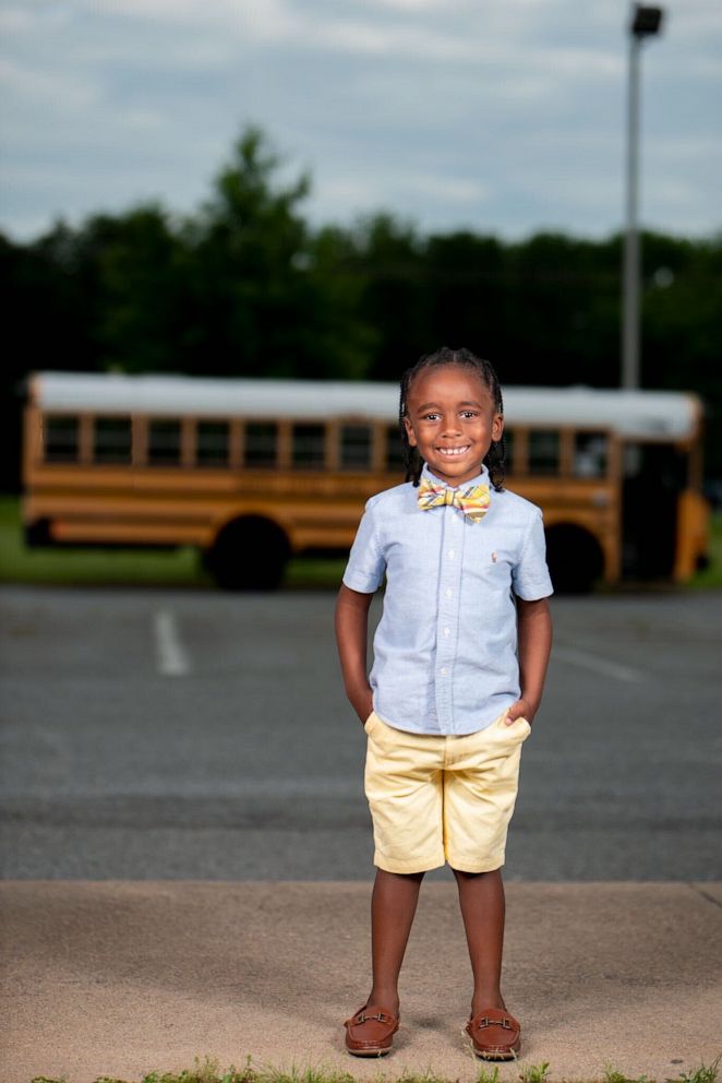 PHOTO: Bryce Latimer poses near school buses. With help from mom and dad, Bryce built a space that resembles an elementary school classroom. The 6-year-old started the setup after opting for virtual learning during the pandemic.