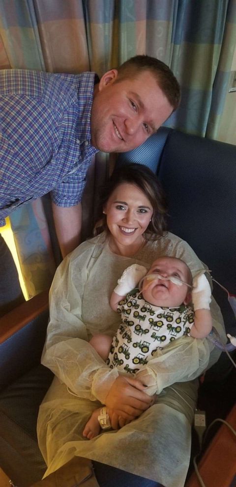 PHOTO: Godparents Savannah and Jake Galloway pose with their godson Oliver.